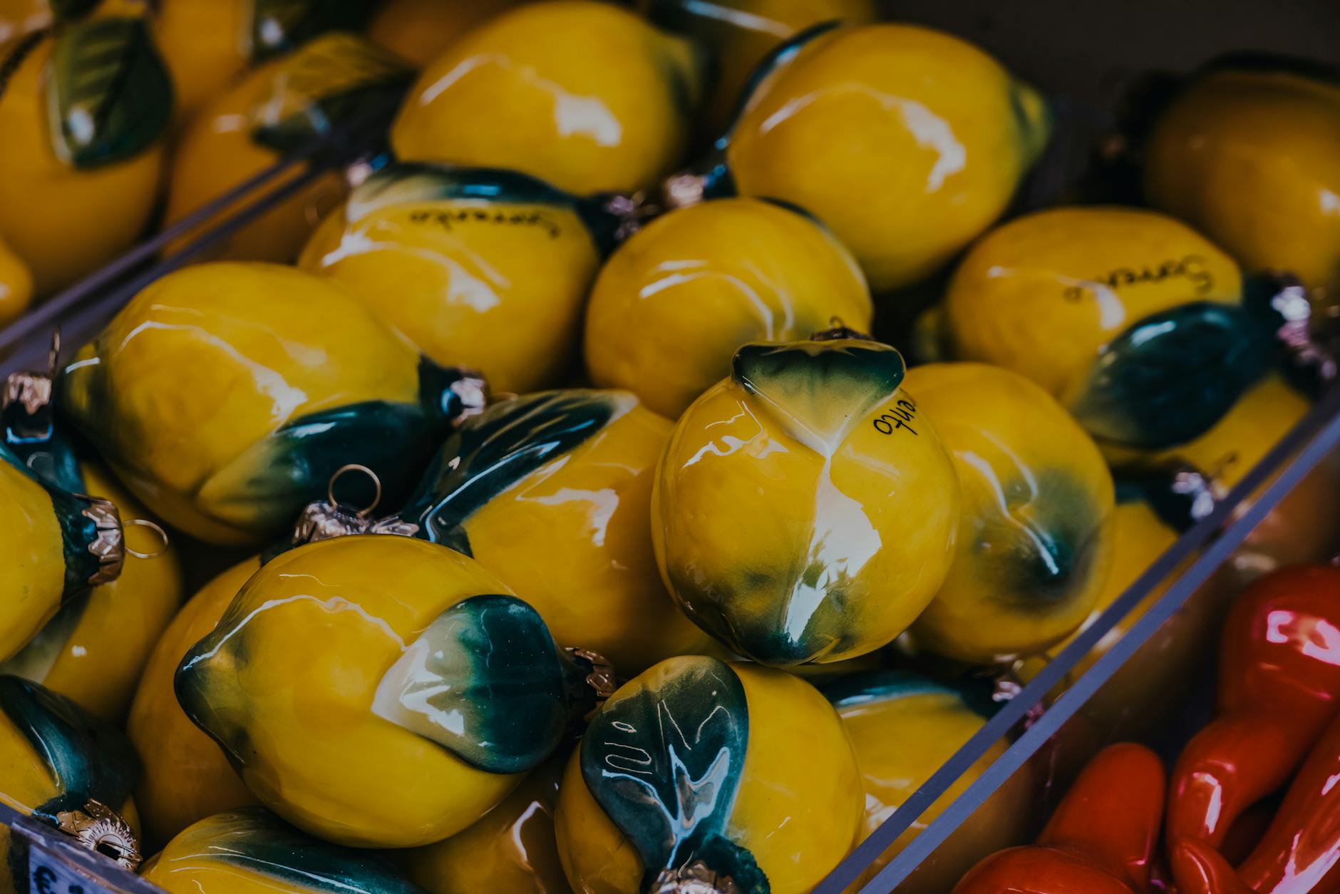 Vibrant yellow ceramic lemons in a market setting, symbolizing the bright, accessible pleasure of lemon vibrators