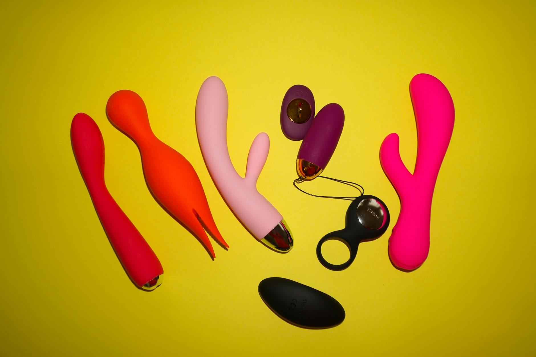 Colorful lemon vibrators and clitoral toys displayed on a bright yellow background